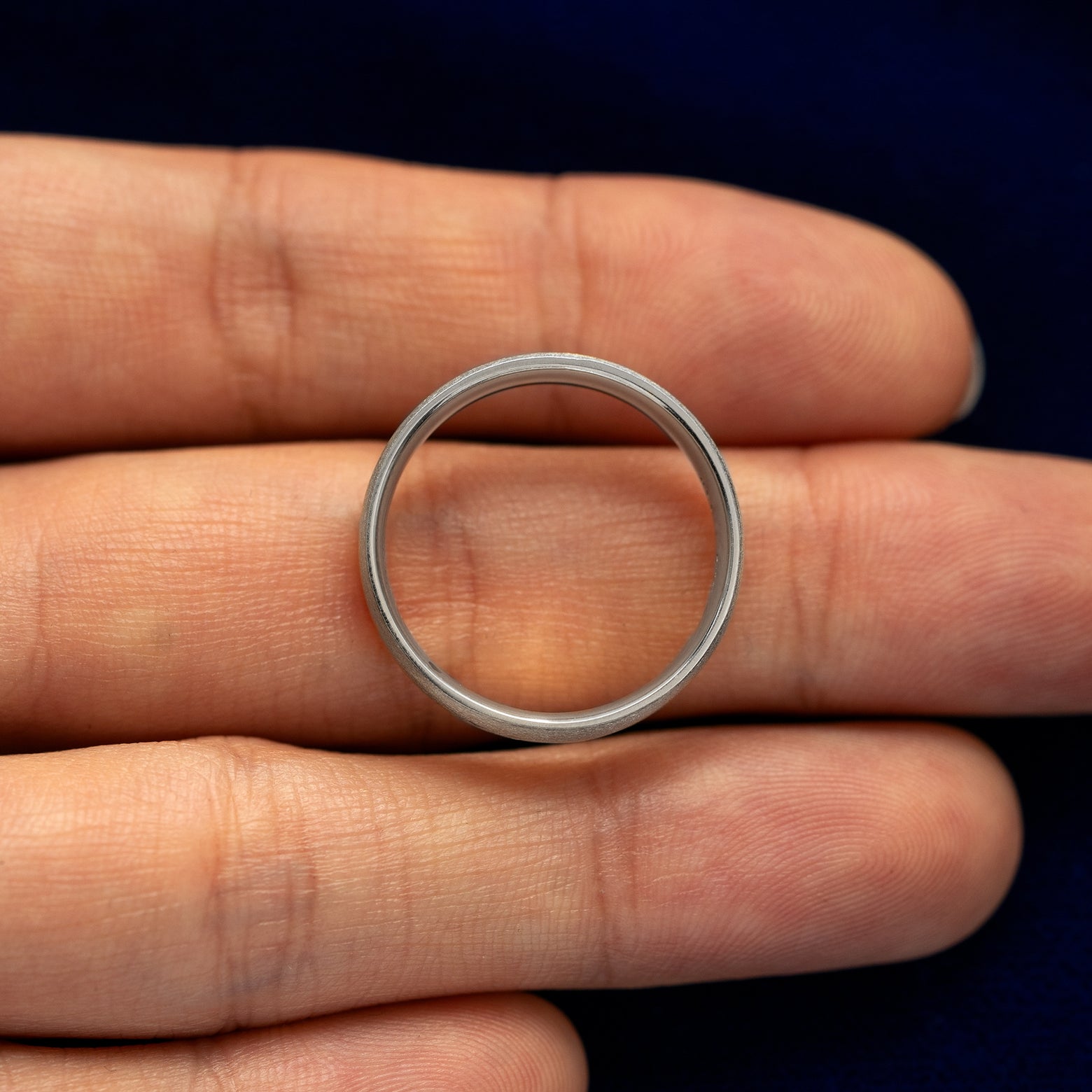 A silver Mix Matte Band in a model's hand showing the thickness of the band