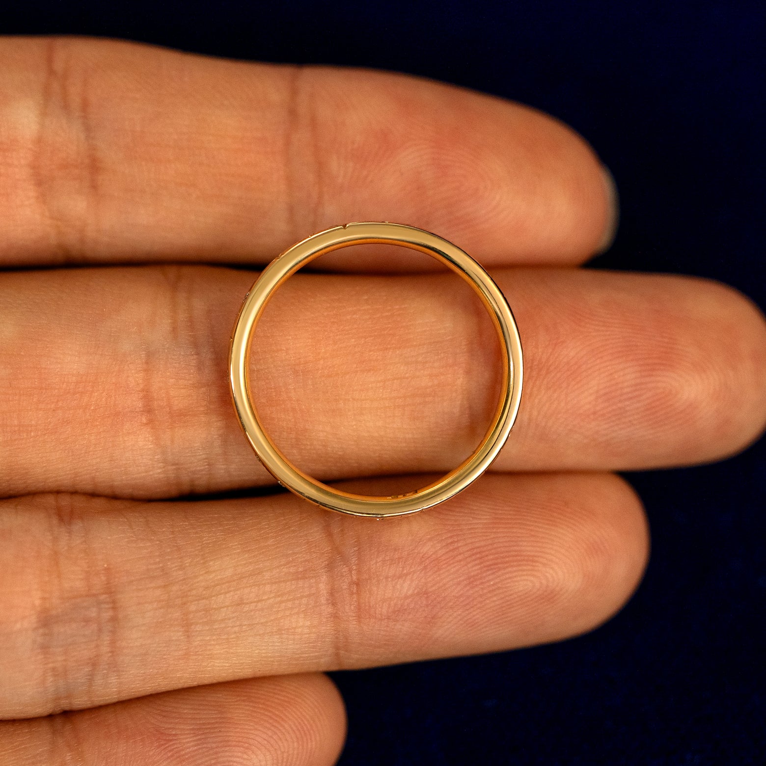 A Mixed Diamond Stars Band lying flat in a models hand to show the thickness of the Ring