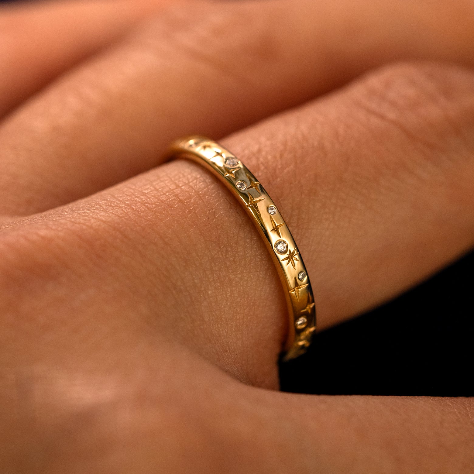 Side view of a Mixed Diamond Stars Band on a model's finger