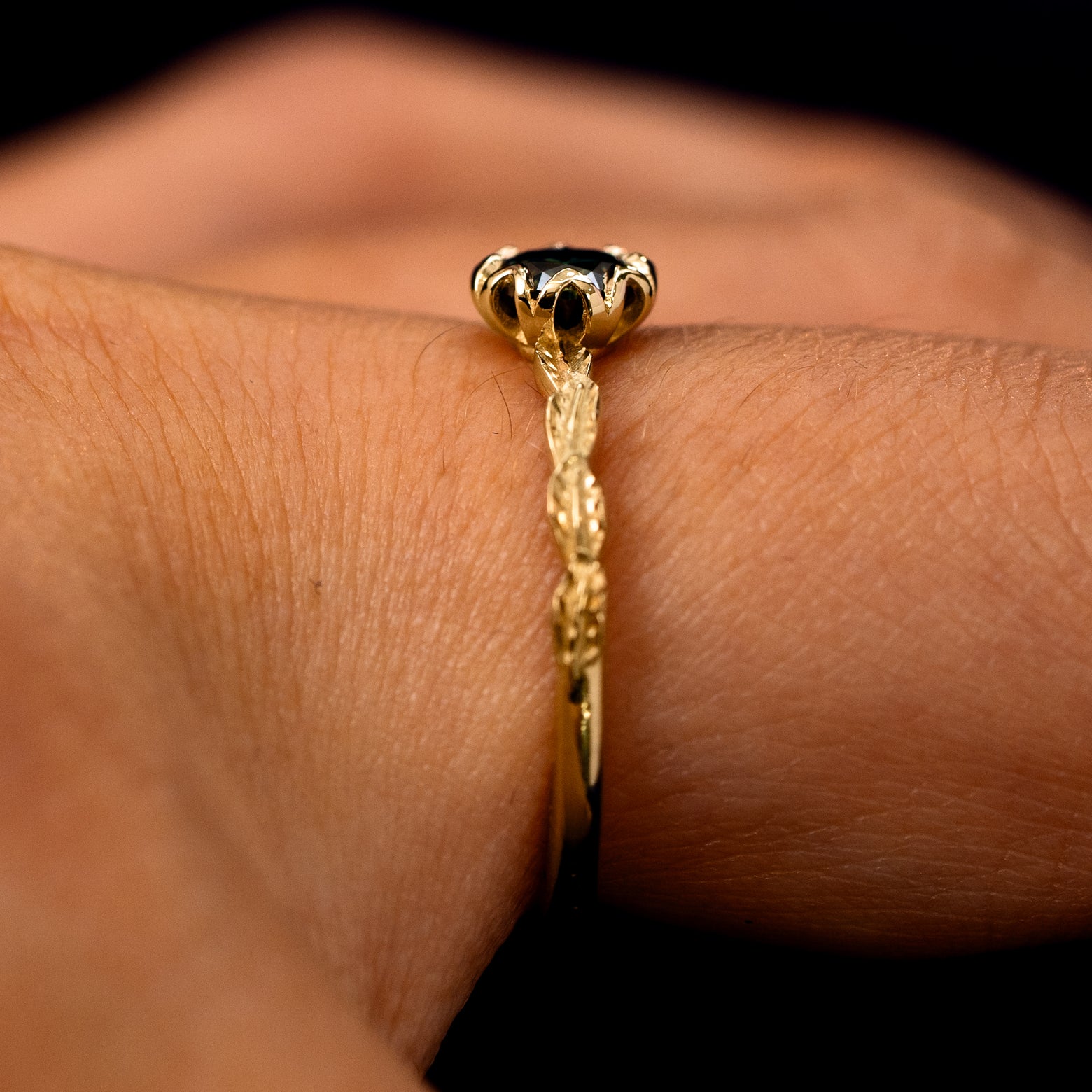 Side view of a Black Moissanite Leaf Ring on a model's finger to show the detailing of the setting