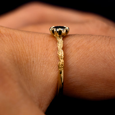 Side view of a Black Moissanite Leaf Ring on a model's finger to show the detailing of the setting