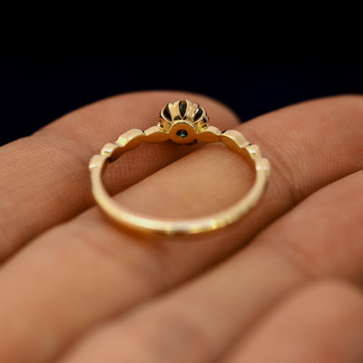 An angled view of a Black Moissanite Leaf Ring resting on a model's fingers to show underneath the setting