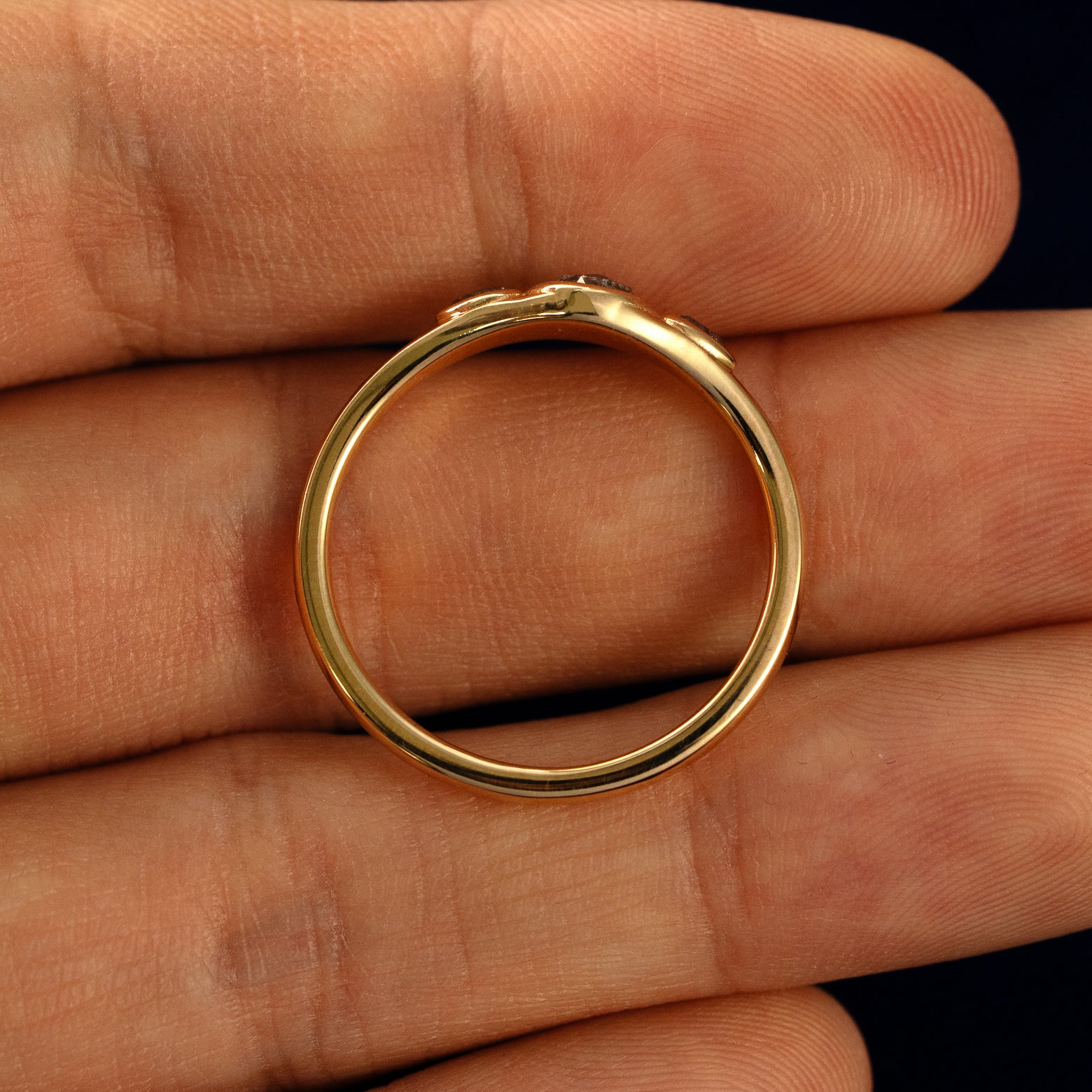 A Moon Cut Salt and Pepper Diamond Ring in a model's hand showing the thickness of the band