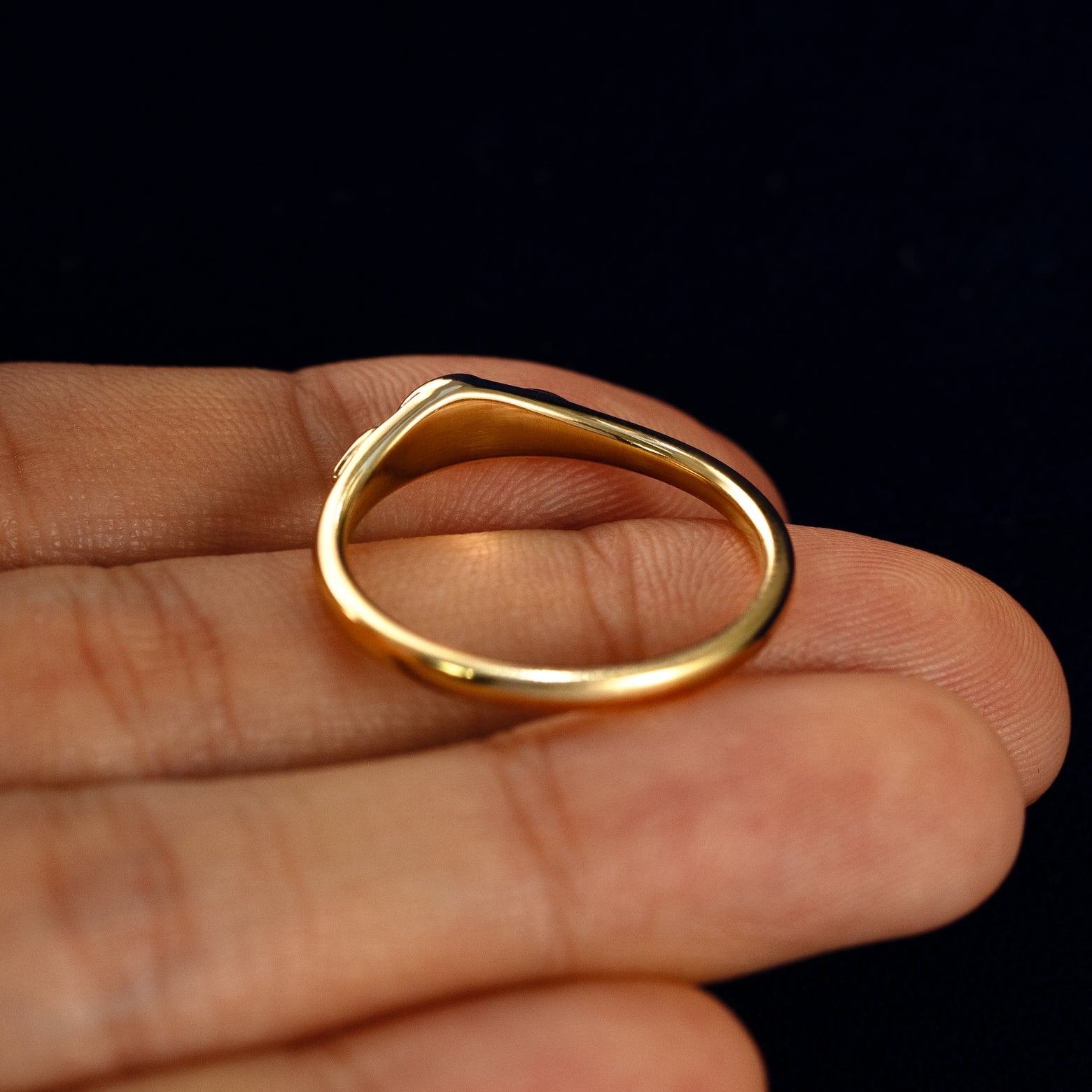 A Moon Cut Salt and Pepper Diamond Ring in a model's hand showing the underside of the stones