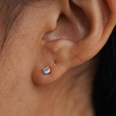 Close up view of a model's ear wearing a 14k yellow gold Moonstone Earring