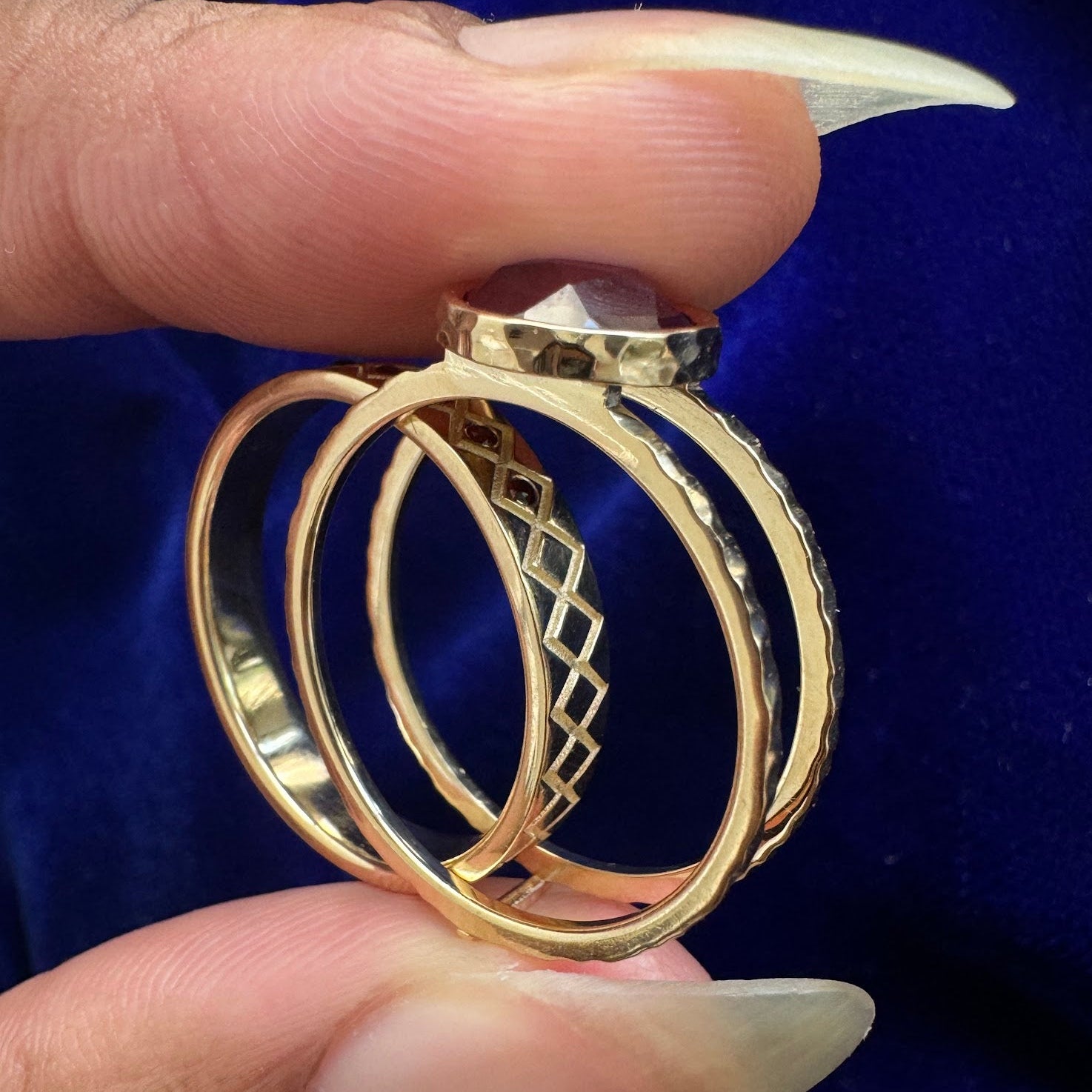 A model holding an alexandrite reverse ring guard with the wedding band half inside the engagement ring