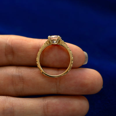 A yellow gold Old Mine Cut Lab Diamond Filigree Ring in a model's hand showing the thickness of the band