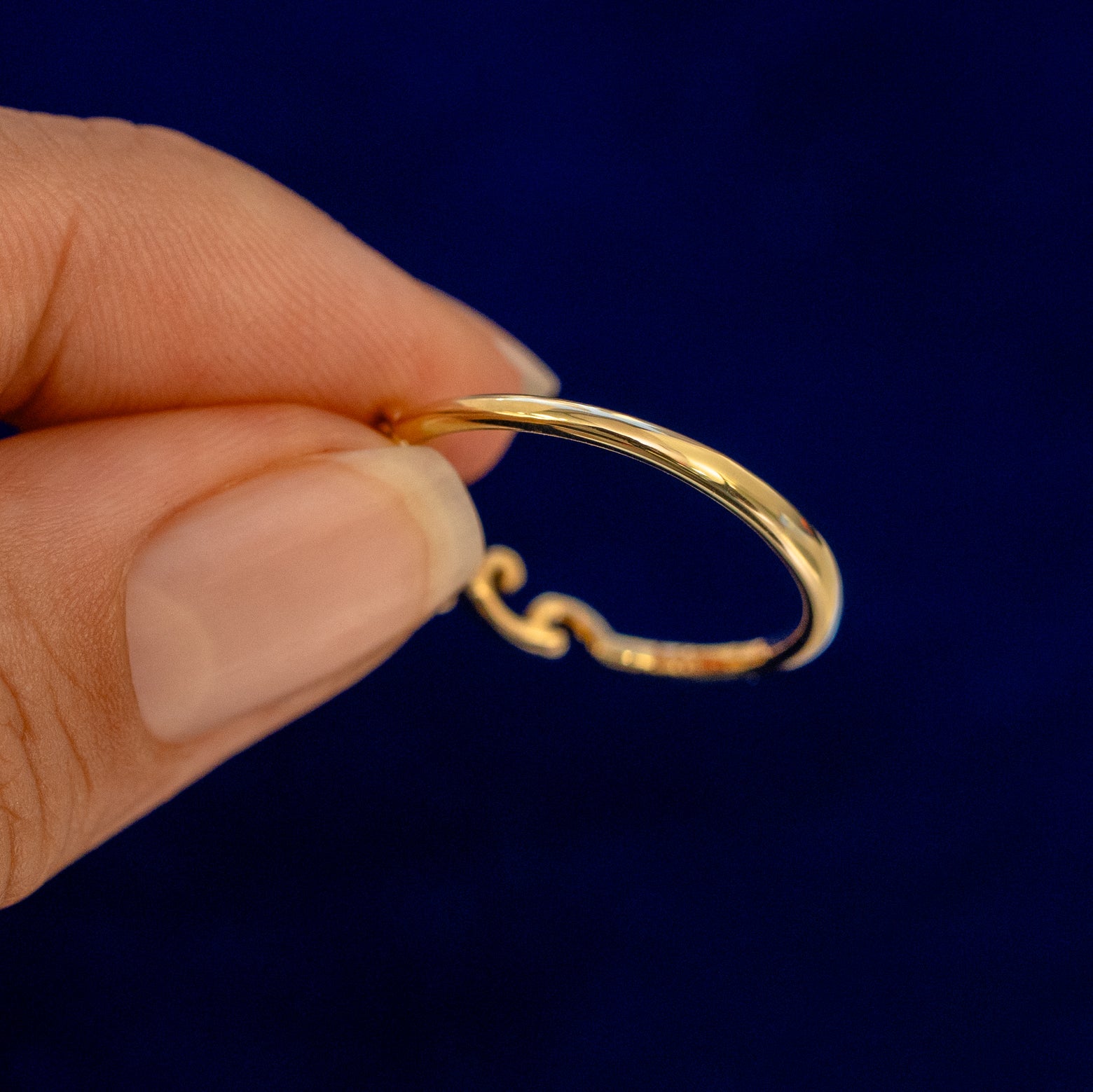 A model holding an Open Filigree Chevron Diamond Band backward to show the details of the back of the band