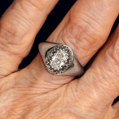 Close up view of a model's fingers wearing a 950 platinum Oval Diamond Signet Ring 