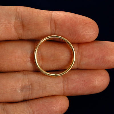 A Flush Set Oval Diamond Ring in a model's hand showing the thickness of the band