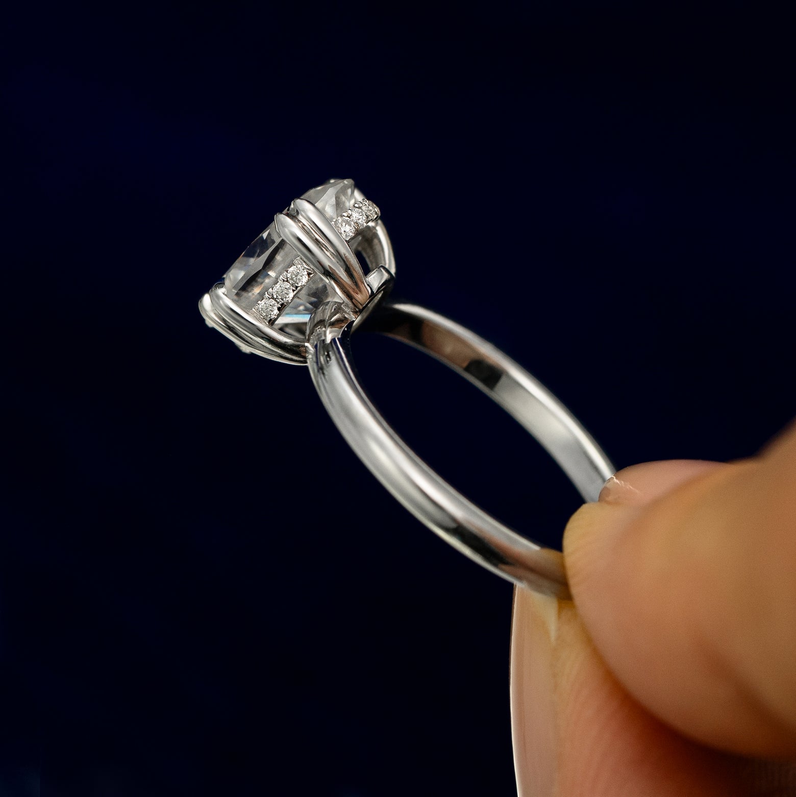 A model holding a Oval Moissanite Halo Ring tilted to show the details of the ring