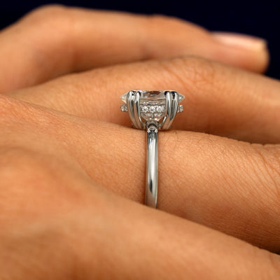 Side view of a Oval Moissanite Halo Ring on a model's finger to show the hidden halo