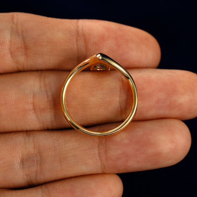 A Pear Salt and Pepper Diamond Chevron Ring in a model's hand showing the thickness of the band