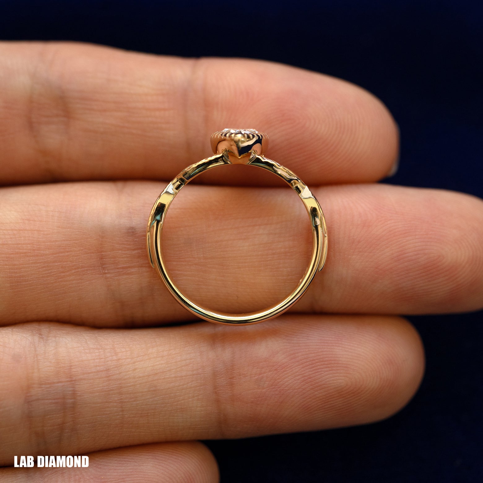 A yellow gold Pear Lab Diamond Leaves Ring in a model's hand showing the thickness of the band