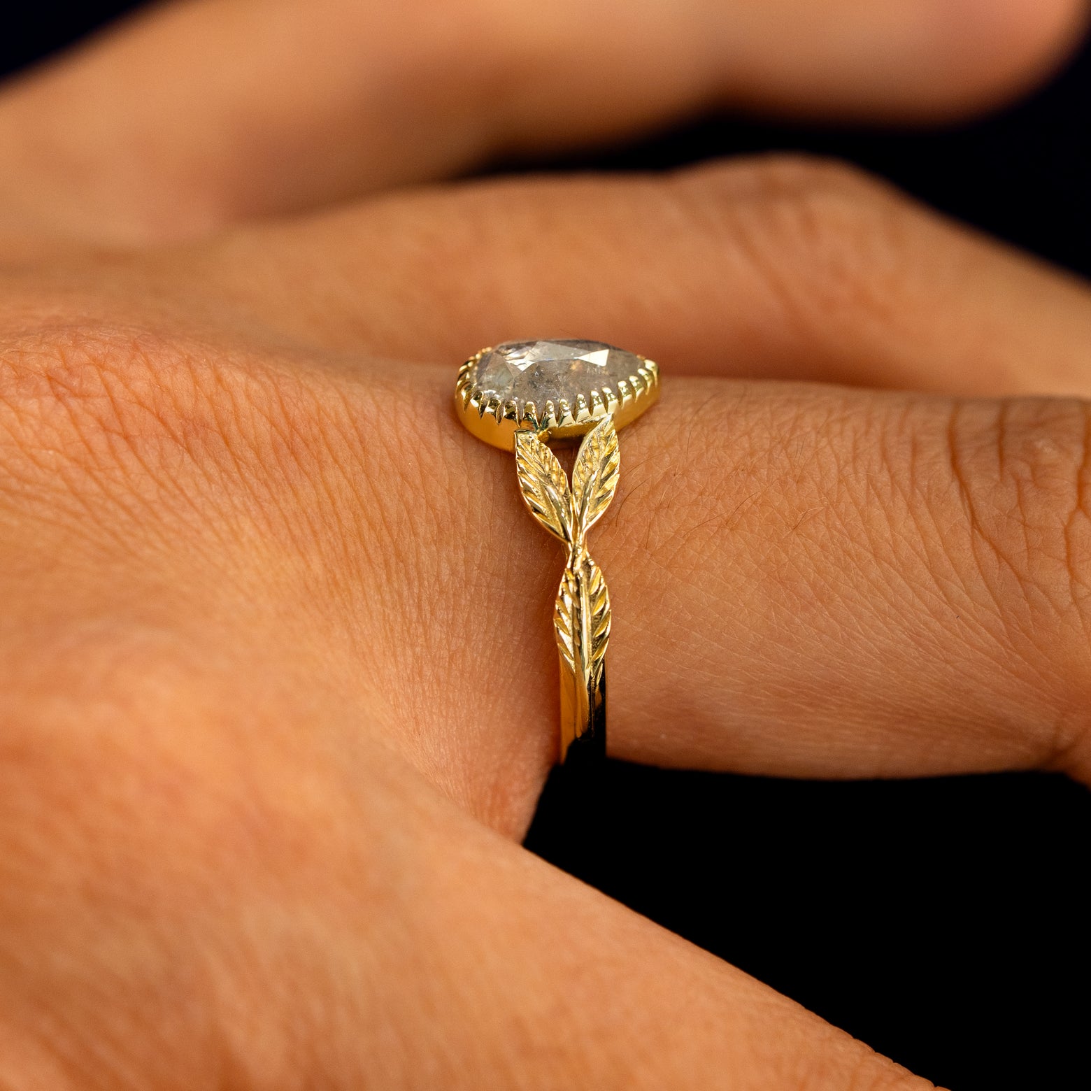 Side view of a Pear Salt and Pepper Diamond Leaves Ring on a model's finger