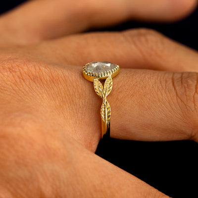 Side view of a Pear Salt and Pepper Diamond Leaves Ring on a model's finger