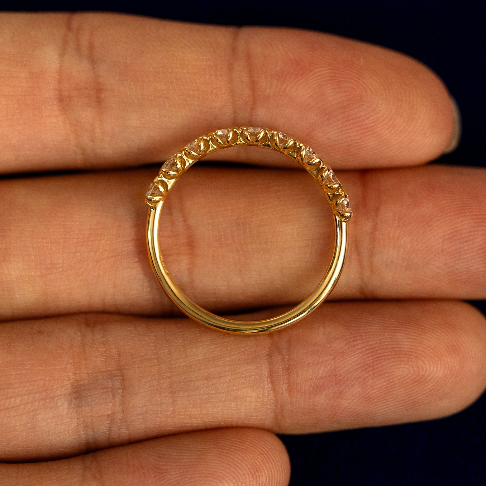 A Petal Set Diamond Eternity Band lying flat in a models hand to show the thickness of the Ring