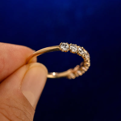 A model holding a Petal Set Diamond Eternity Band up to show the details of the design and the inside of the ring