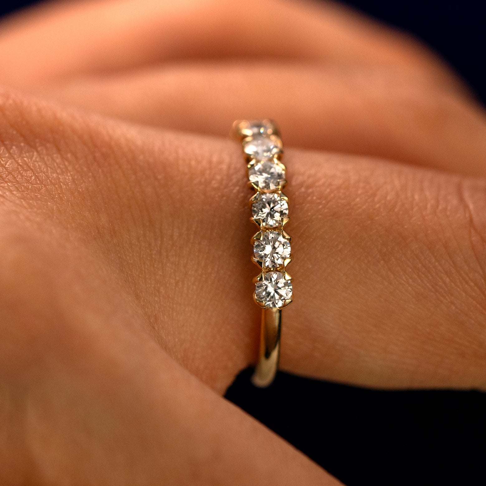 Side view of a Petal Set Diamond Eternity Band on a model's finger