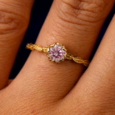 A solid 14k yellow gold Pink Moissanite Leaf Ring on a model's finger