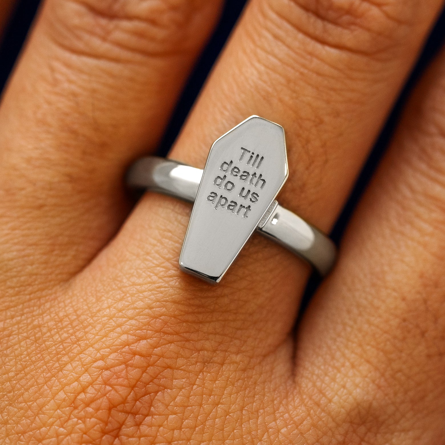 Close up view of a model's hand wearing a platinum Coffin Ring in the closed position