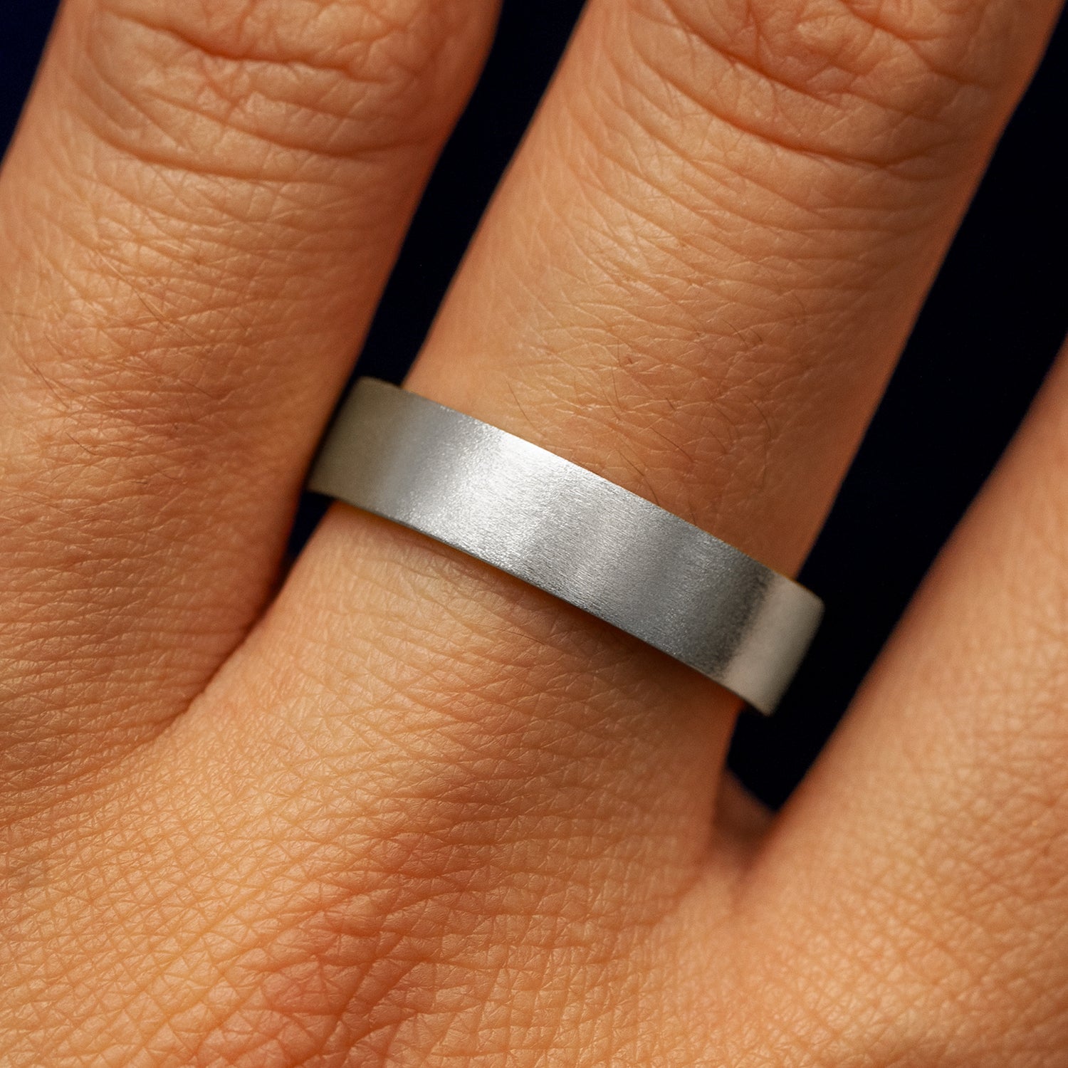 Close up view of a model's fingers wearing a platinum Industrial Matte Band
