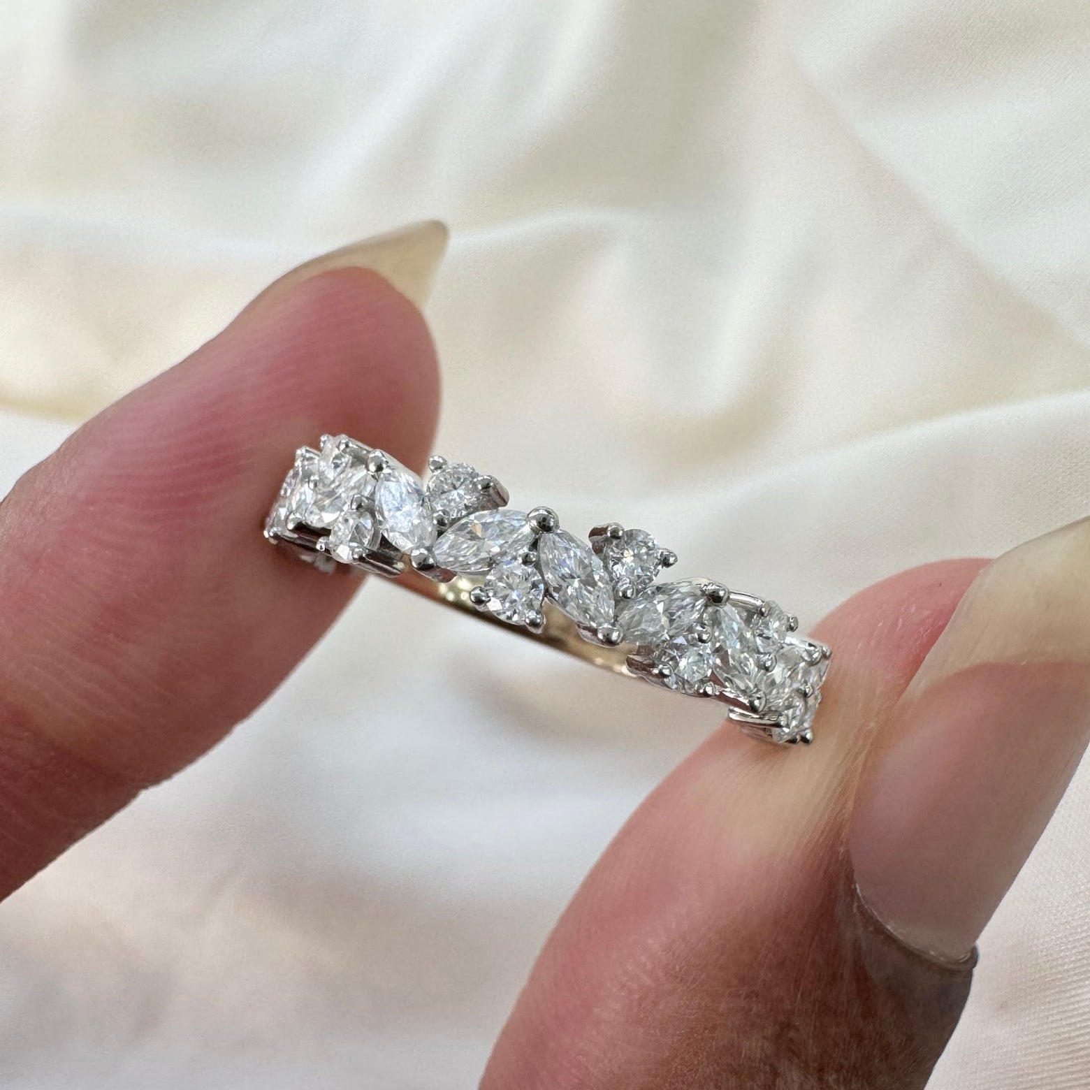 A model holding a custom round and marquise moissanite wedding band made from solid 950 platinum