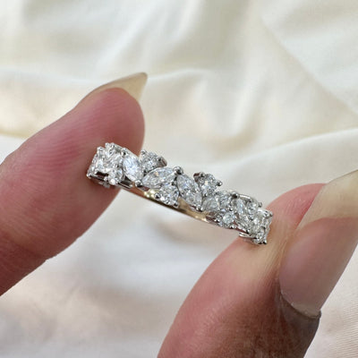 A model holding a custom round and marquise moissanite wedding band made from solid 950 platinum