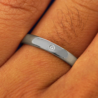 Close up view of a model's fingers wearing a Platinum Mix Mirror Band with three diamonds