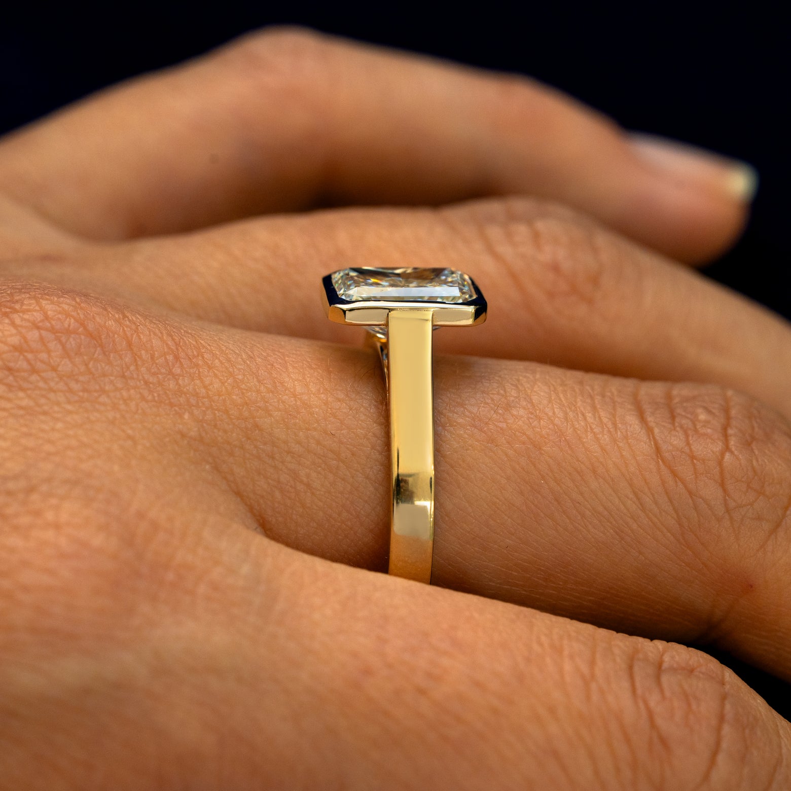 Side view of a Radiant Cut Lab Diamond Cathedral Ring on a model's finger to show the height of the stone