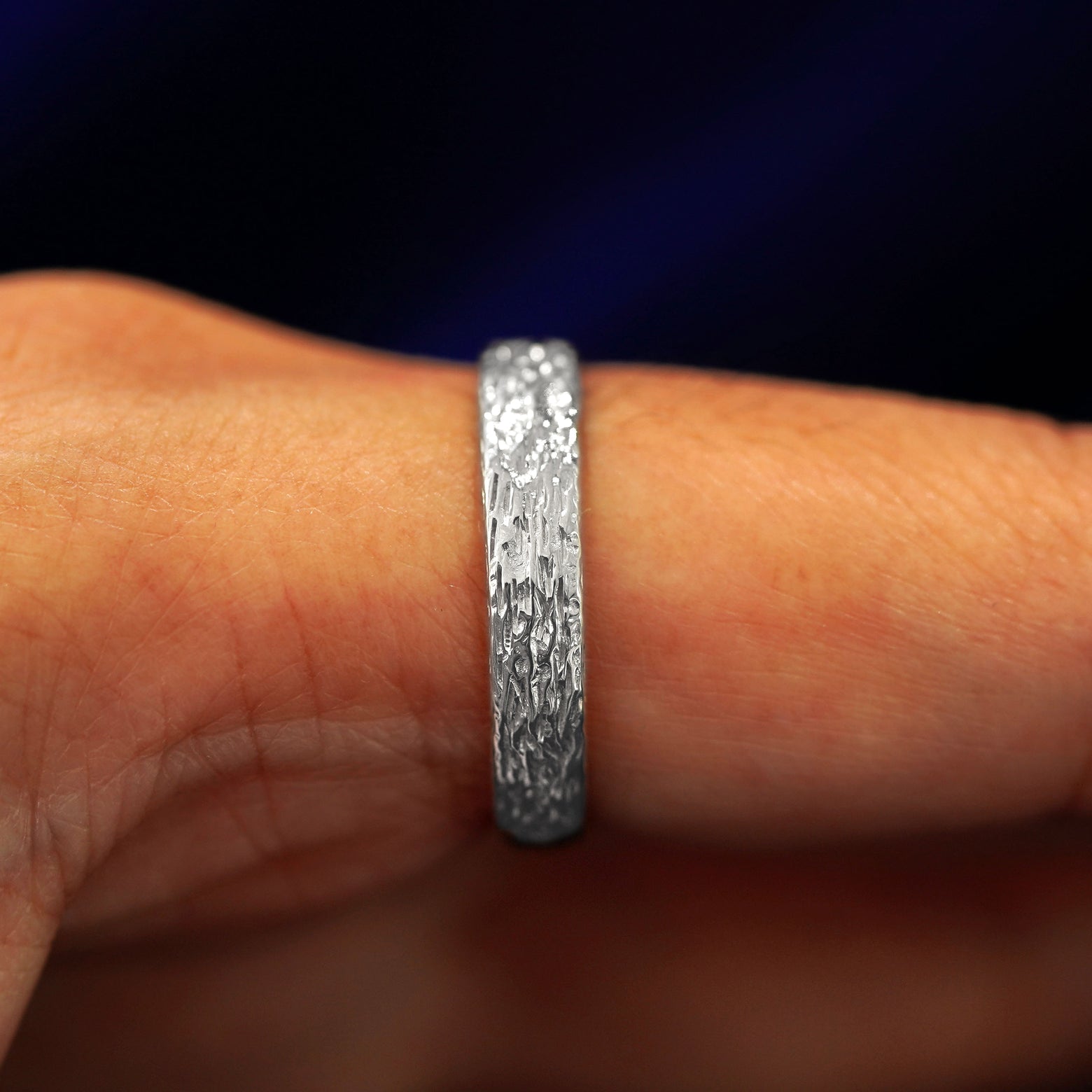 Side view of a 925 sterling silver Raw Band on a model's finger