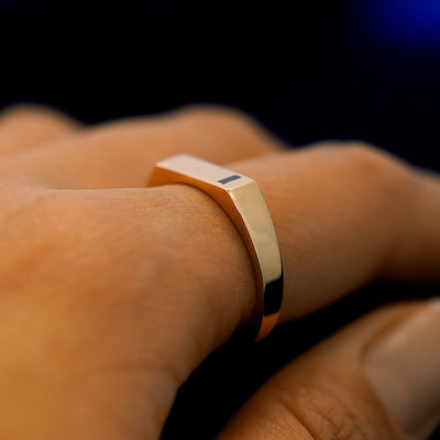 Side view of a model wearing a baguette salt and pepper diamond rectangular signet ring to show the height of the ring