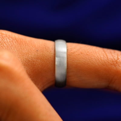 Side view of a Silver Curvy Matte Band on a model's finger