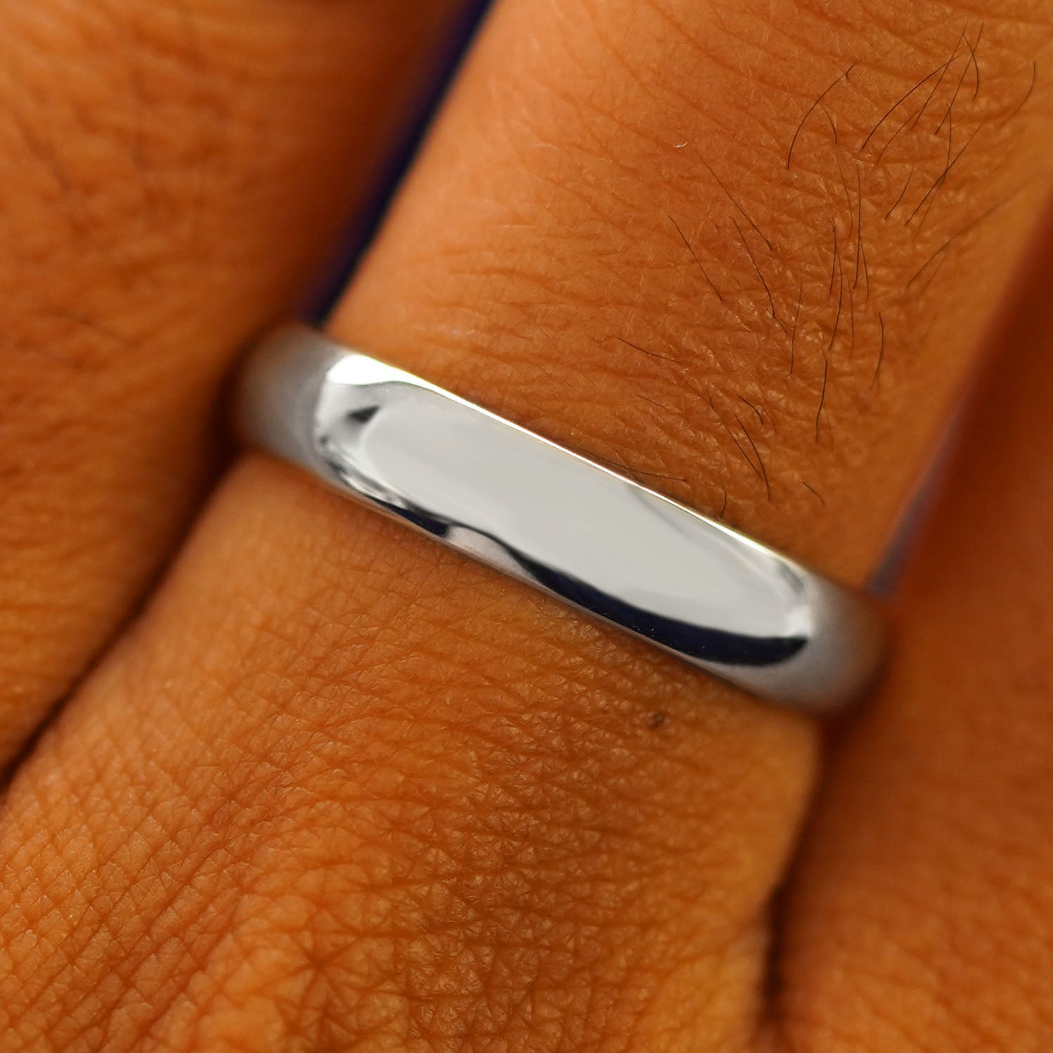 Close up view of a model's fingers wearing a 4mm 925 silver Curvy Mirror Band