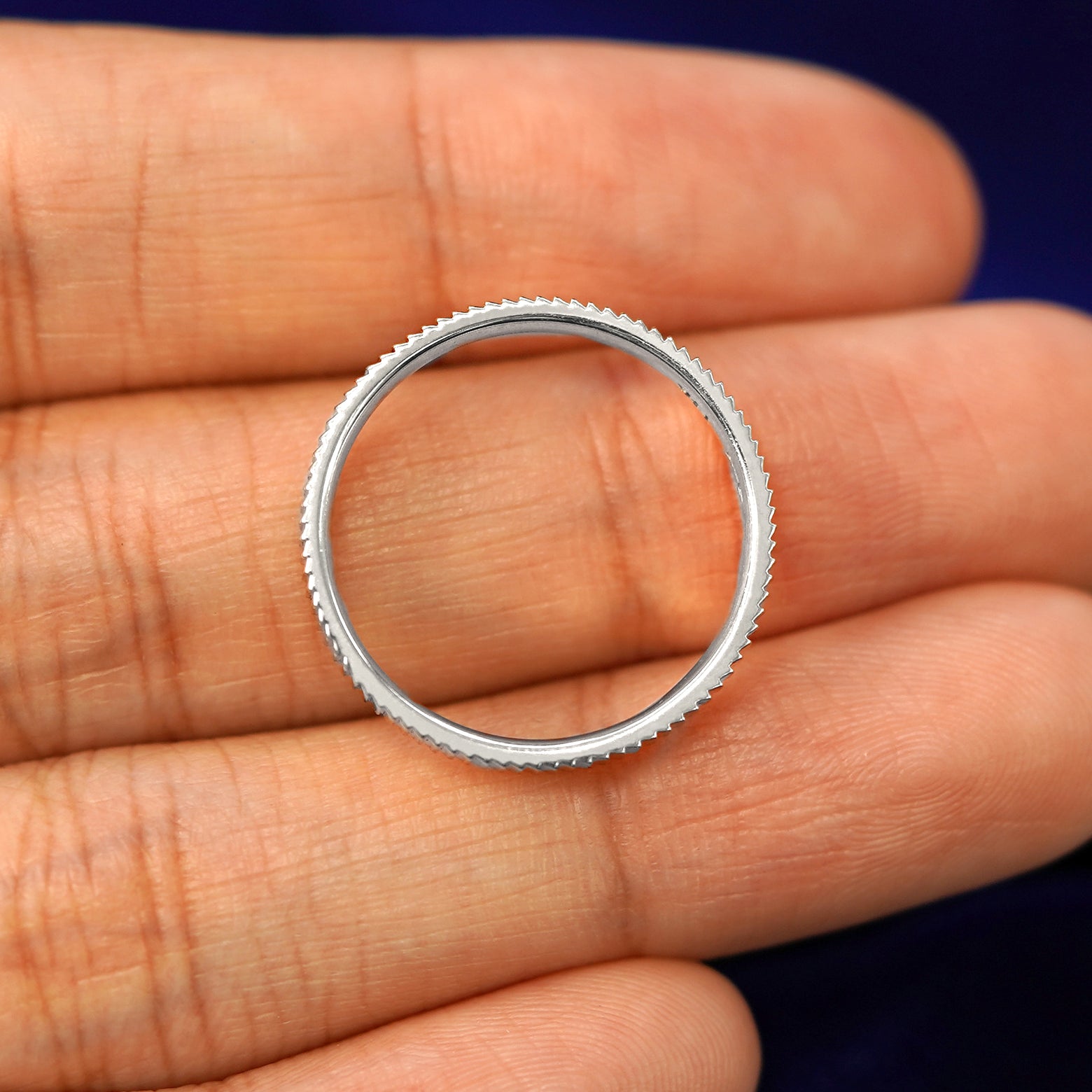 A Silver Edge Band in a model's hand showing the thickness of the band