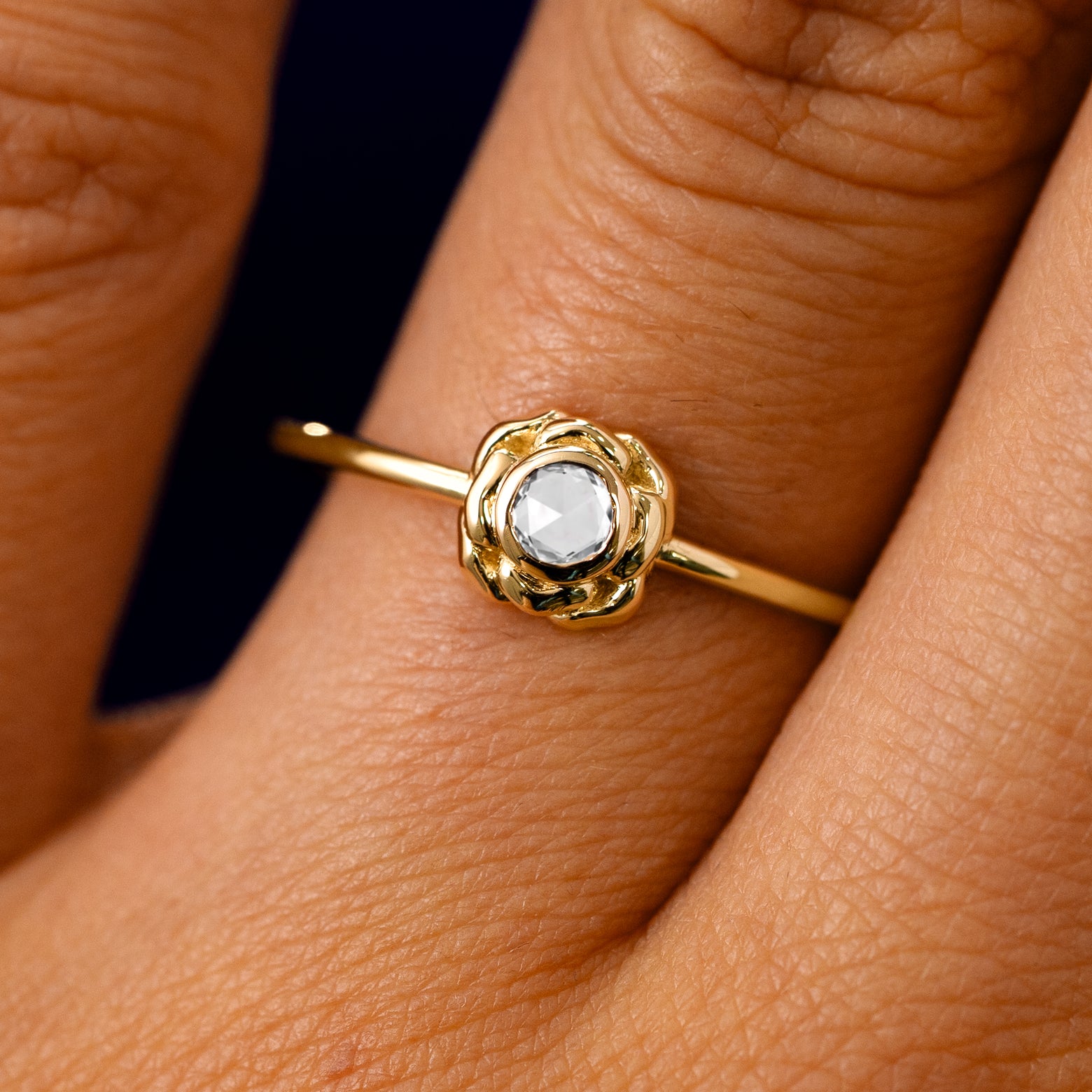 A solid 14k yellow gold Rose Cut Diamond Flower Ring on a model's finger