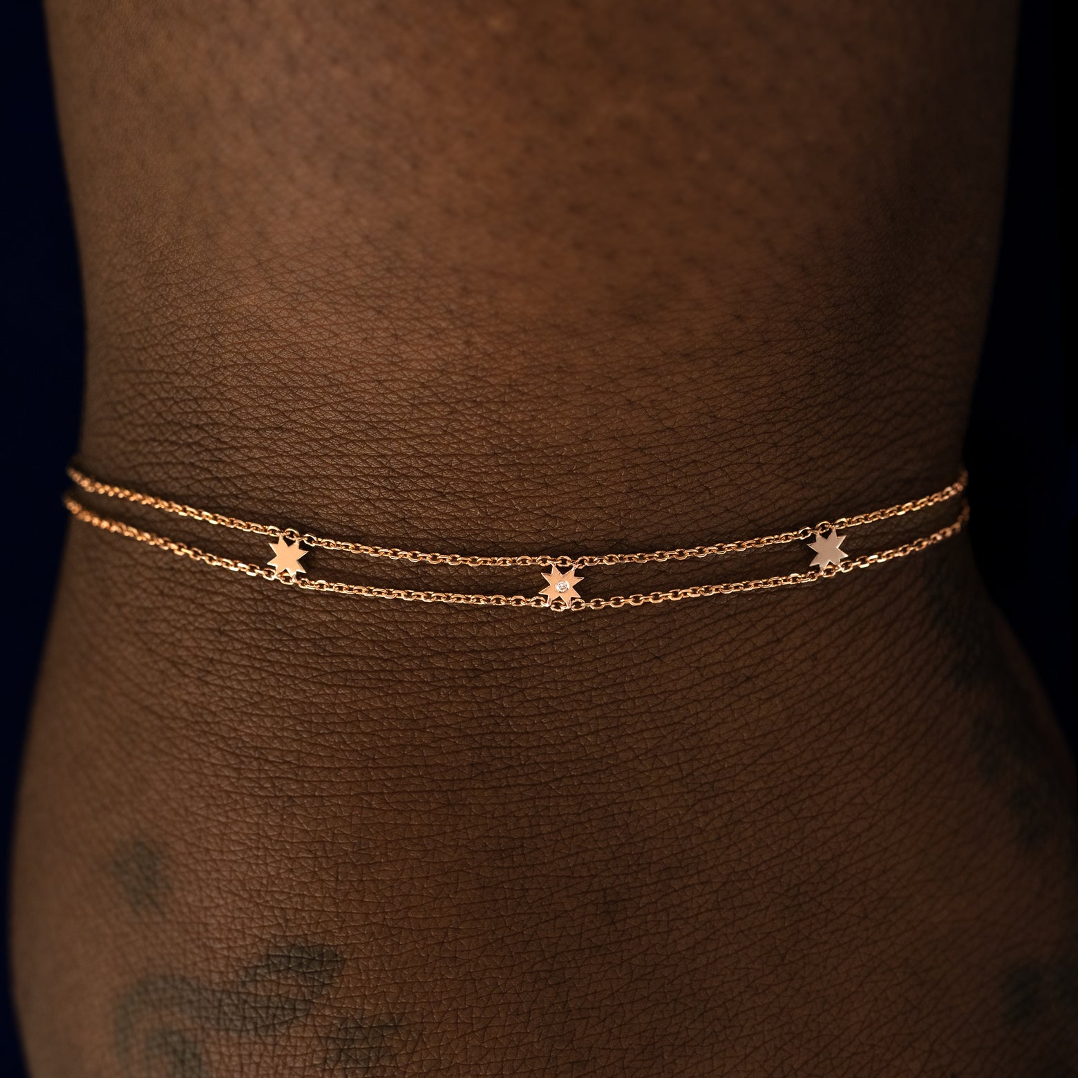 A model wearing a rose gold 8 pointed star bracelet