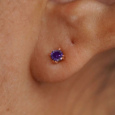 Close up view of a model's ear wearing a 14k rose gold Amethyst Stud Earring