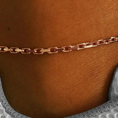 Close up view of a model's ankle wearing a rose gold Anchor Anklet