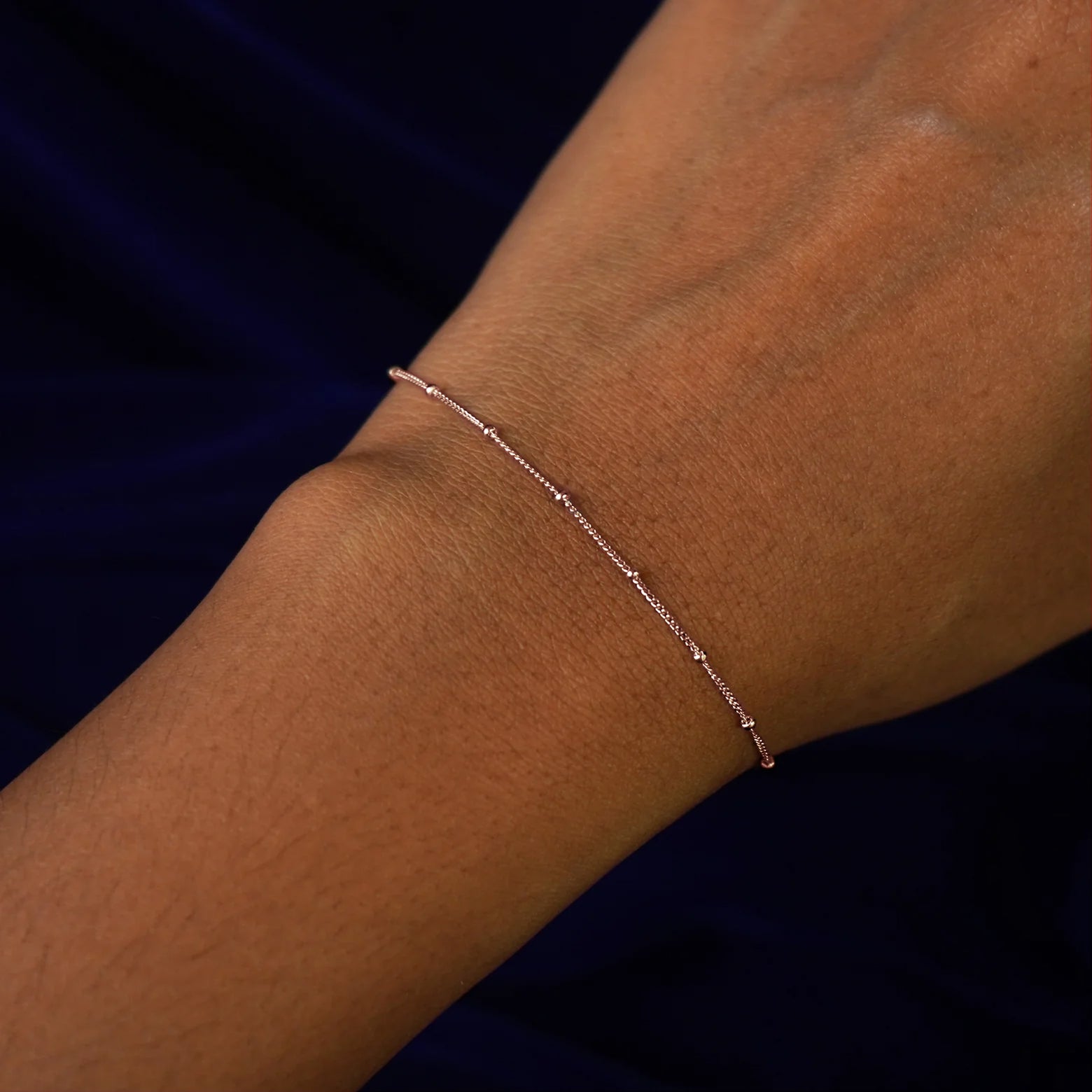 Close up view of a model's wrist wearing a rose gold Beads Bracelet