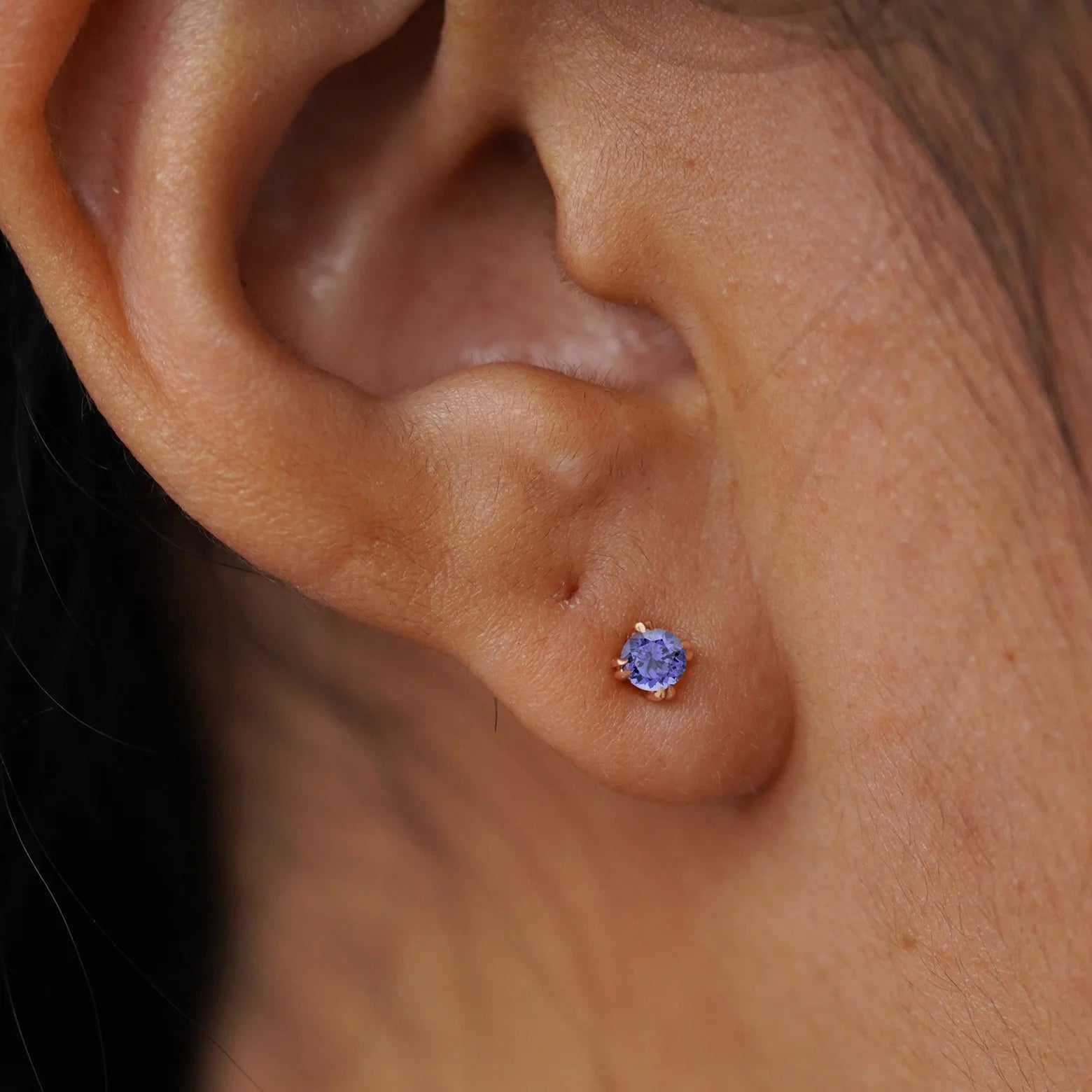 Close up on ear of a rose gold tanzanite stone