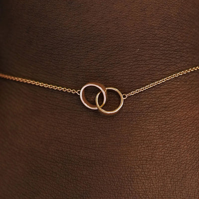 Close up view of a model's wrist wearing a  rose solid gold Bound Together Bracelet
