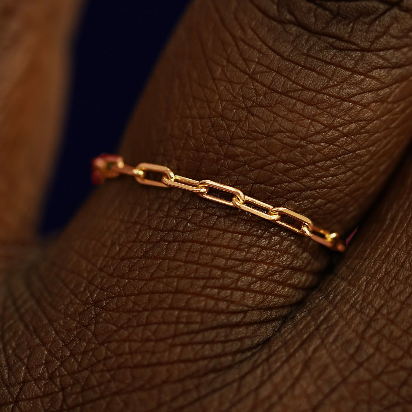Close up view of a model's fingers wearing a 14k rose gold Butch Chain Ring