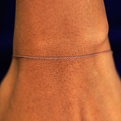 A model's wrist wearing a solid 14k rose gold Cable Bracelet