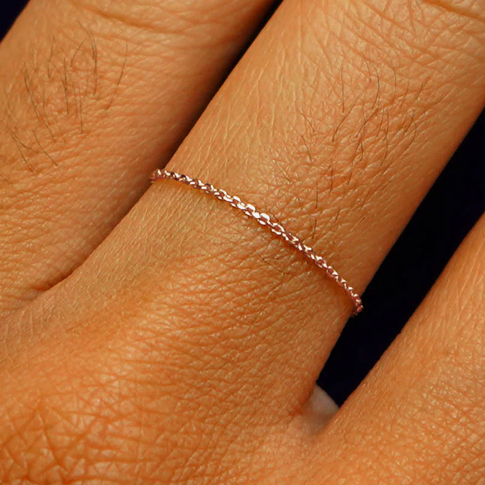 Close up view of a model's fingers wearing a 14k rose gold Cable Chain Ring