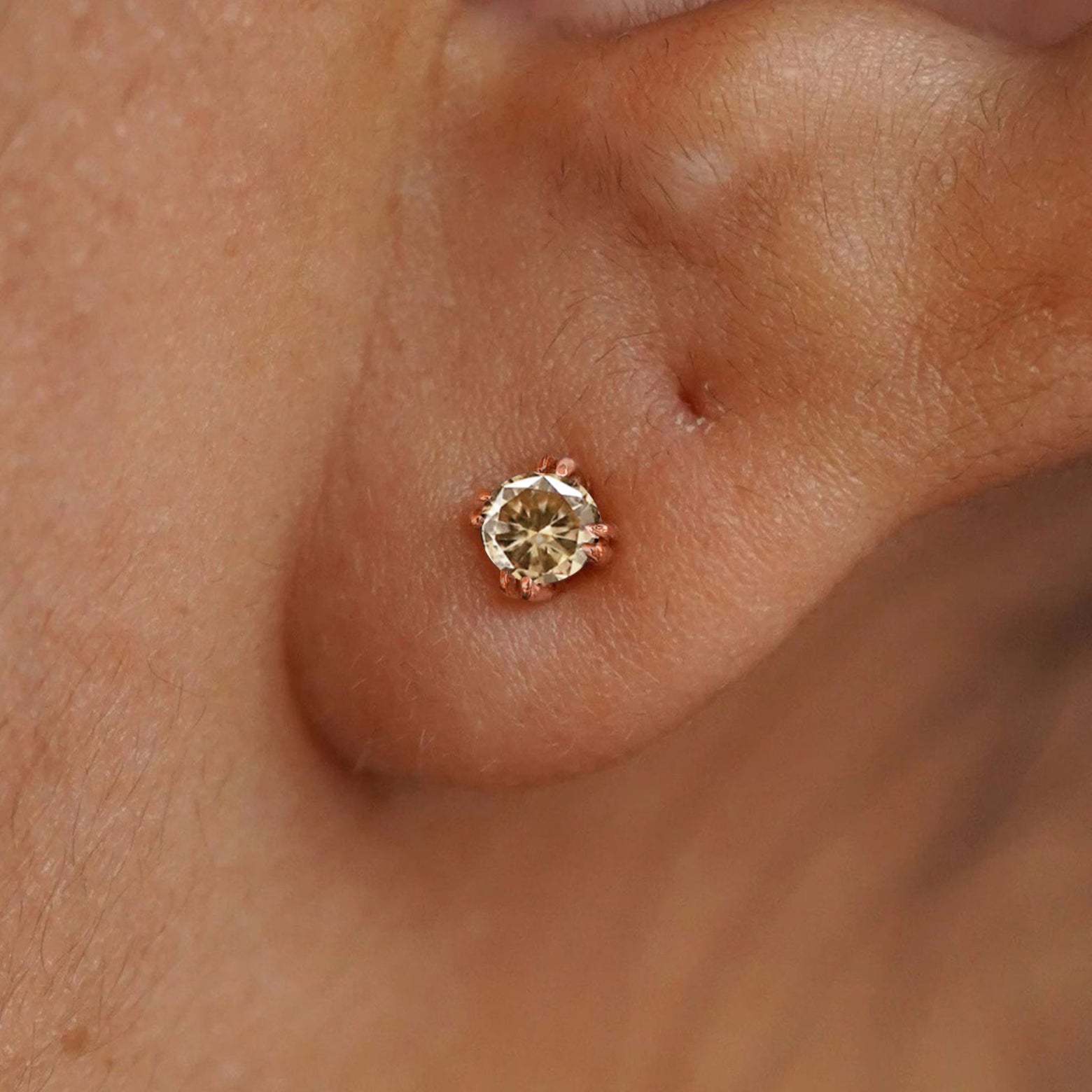 A model's ear wearing a 14k rose gold Champagne Diamond Earring