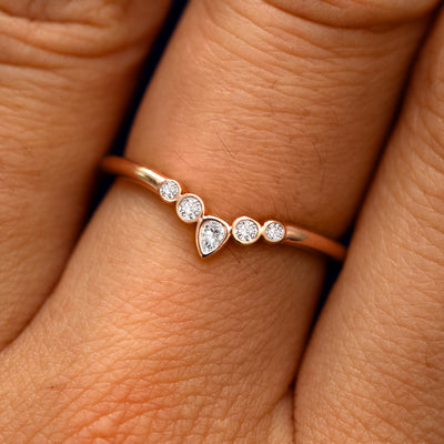 Close up view of a model's fingers wearing a 14k rose gold Chevron Tiara Diamond Band