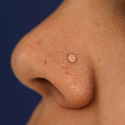 Close up view of a model's nose wearing a rose gold Circle Nose Stud