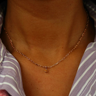 Close up view of a model's neck wearing a rose gold Citrine Charm on a Butch Chain