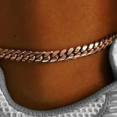 Close up view of a model's ankle wearing a rose gold Miami Cuban Anklet